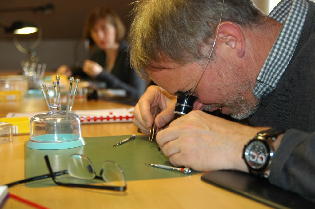 Charles, conseil en brevet, concentré pendant le remontage d'une montre